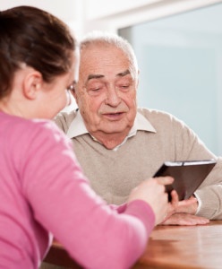 Young woman and senior man with tablet pc