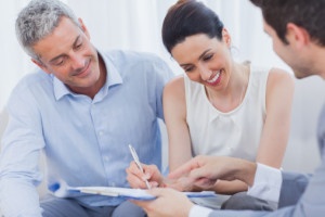 Smiling woman sign on a contrat with her partnership on sofa