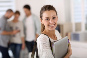 Smiling student girl holding books