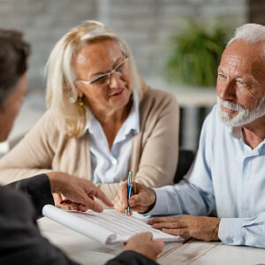 Estate planning attorney explaining documents to an over 65 year old husband and wife